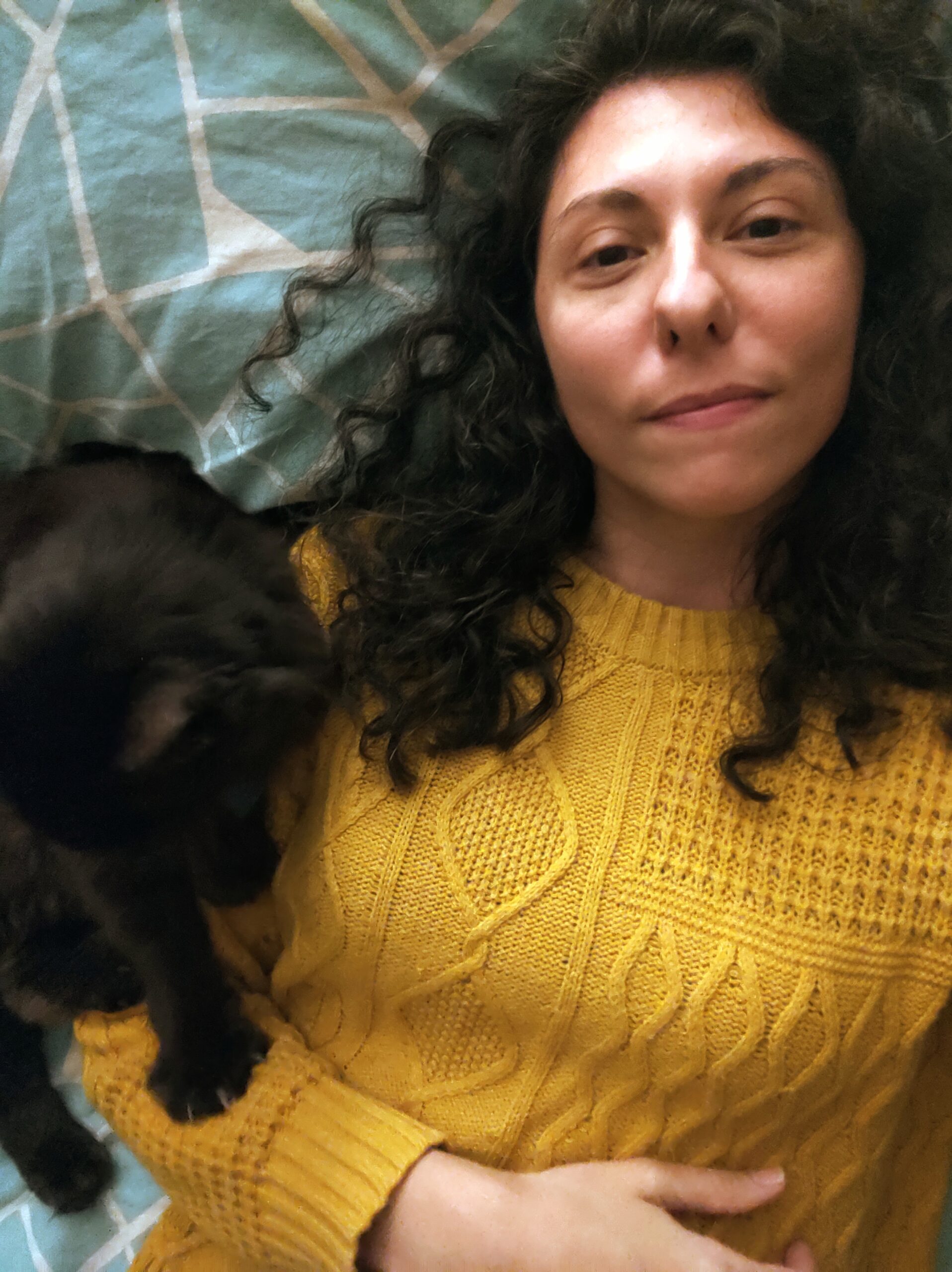 Reflection. Rest. Realization. What I've been up to...the last 4 months of 2023. Author laying down in yellow sweater with her black cat